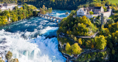 Rhine Falls or Rheinfall, Switzerland panoramic aerial view. Tourist boat in waterfall. Bridge and border between the cantons Schaffhausen and Zurich. Cliff-top Schloss Laufen castle, Laufen-Uhwiesen.
