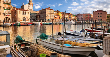 Chioggia, Venice, Italy: landscape of the old town and the canal with fishing boats and ancient buildings