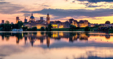 View of the city of Mantua at sunset reflected on the Middle Lake on the Mincio River